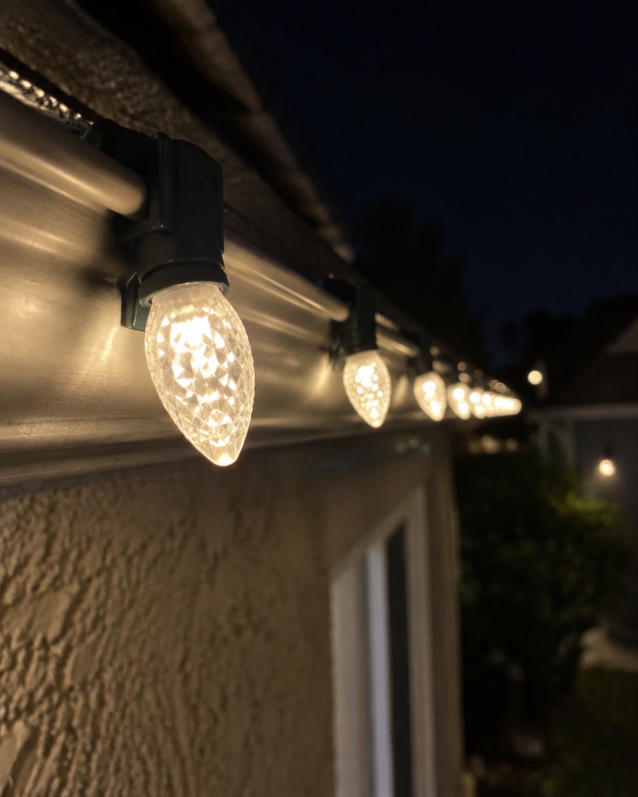 Close-up of commercial-grade warm-white C9 LED bulbs clipped evenly along a gutter